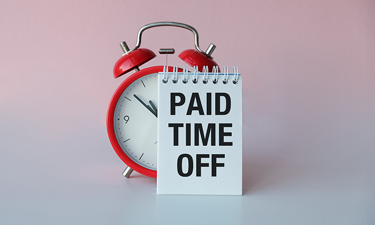How PTO Accrual Works - PEOPayGo - PEOPayGo Red alarm clock next to a notebook displaying 'PAID TIME OFF' on a soft pink-to-gray backdrop, symbolizing leave or vacation time.