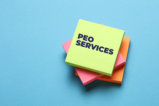 PEO Services Explained - PEOPayGo Neon green sticky note labeled 'PEO SERVICES' atop pink and orange notes on a blue background.