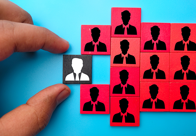 PEO vs ASO Key Differences Explained - PEOPayGo - PEOPayGo A hand places a white silhouette tile among a grid of red tiles with black businessperson icons, forming a team.