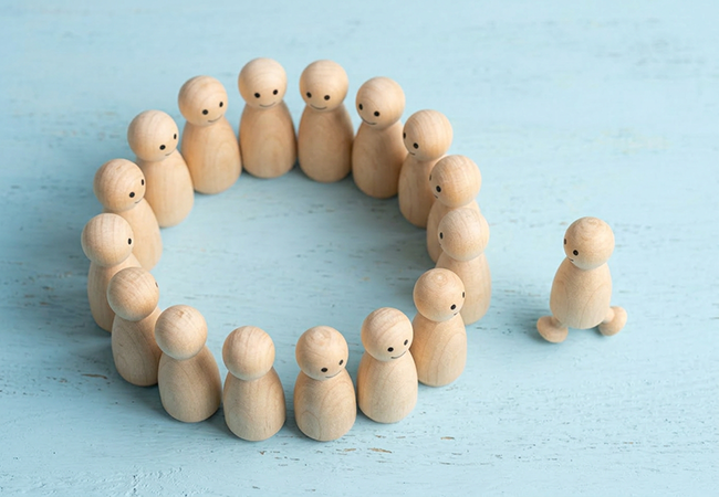 Officer_Owner Exclusion - PEOPayGo - PEOPayGo Wooden peg figure standing apart from a circle of wooden peg figures on a light blue background.